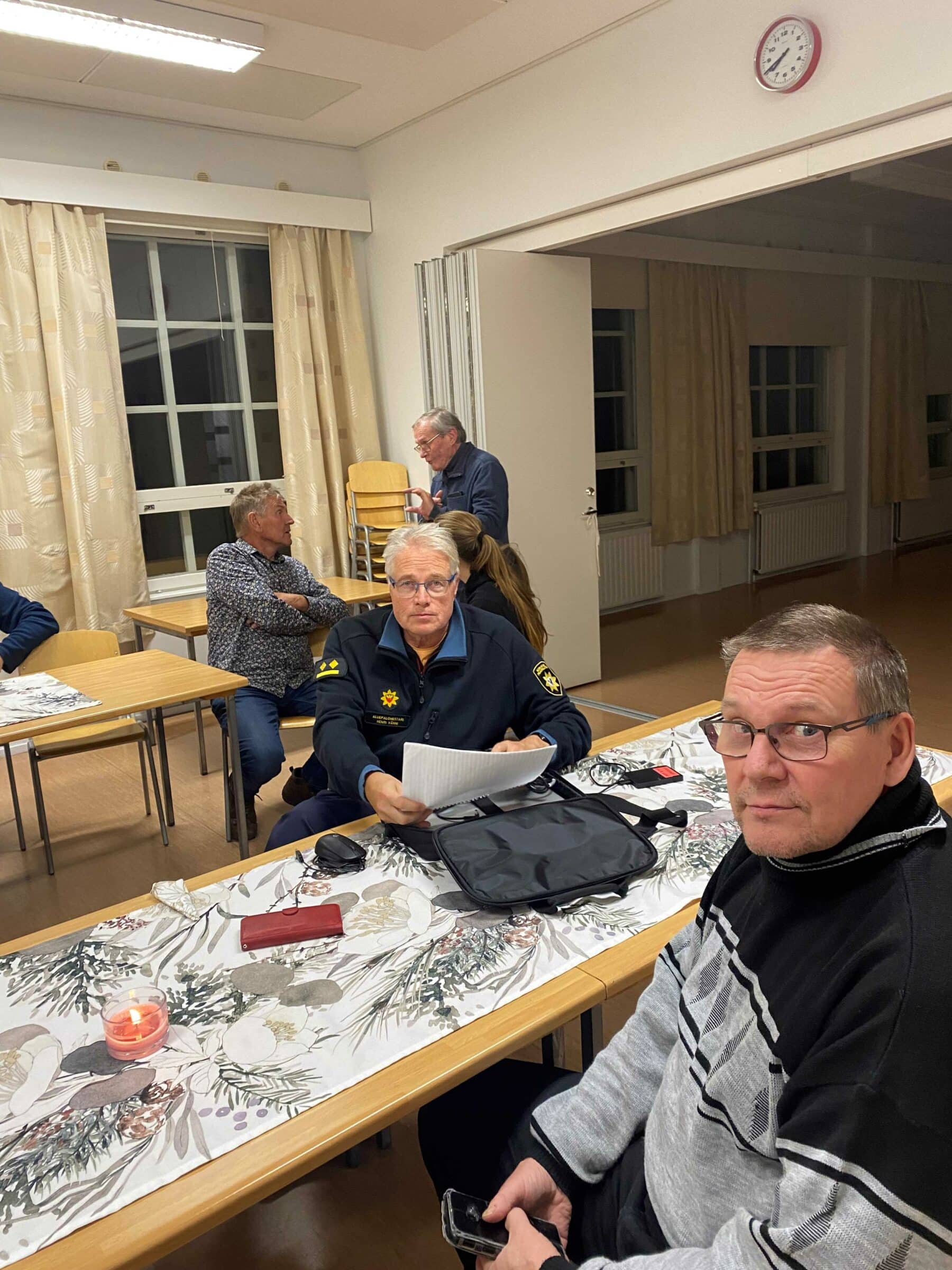Viitasaaren paloaseman päällikkö Henri Vänni, etualalla Reijo Pekkarinen, taustalla Seppo Pietiläinen. Pöydän ääressä ollaan Niinilahden kylätalolla.