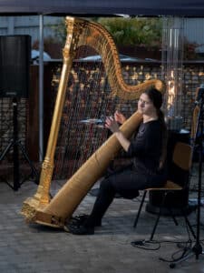 Nainen soittaa harppua ulkona 